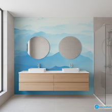 Load image into Gallery viewer, Bathroom with wooden vanity, round mirrors, and a blue mountain mural.