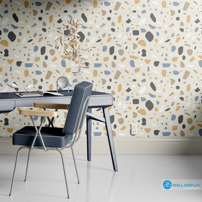 Modern terrazzo pattern wallpaper with beige, blue, tan, charcoal, and white abstract shapes on a neutral background for bathrooms, offices, and feature walls.