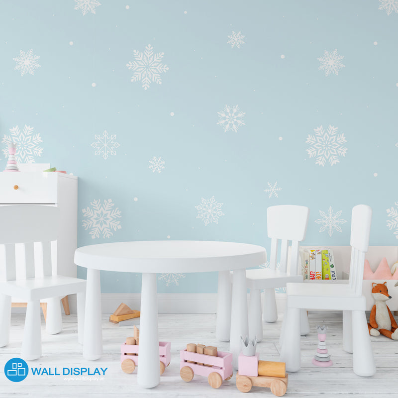Snowflakes kids wallpaper with white snowflake patterns on a pastel blue background for nursery, baby room, and playroom walls.